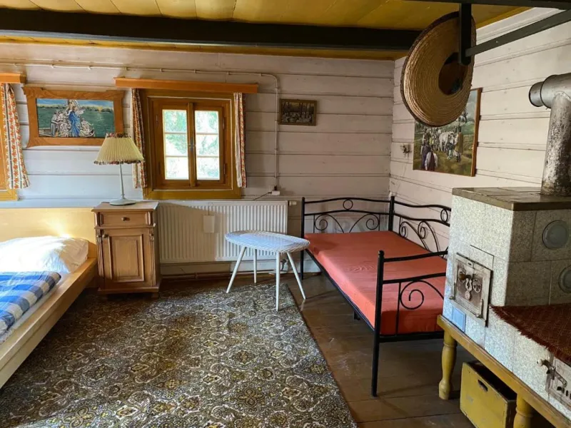 Ložnice v roubence s kachlovými kamny a lůžky