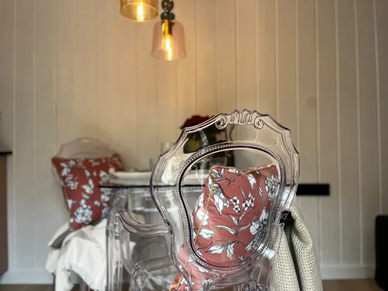 Jídelní kout s průhlednými židlemi a lampami