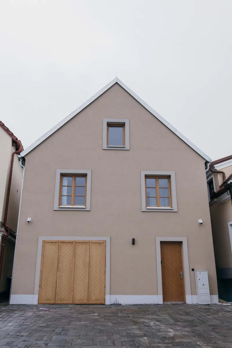 Štítové průčelí domu s dřevěnými vraty a dveřmi