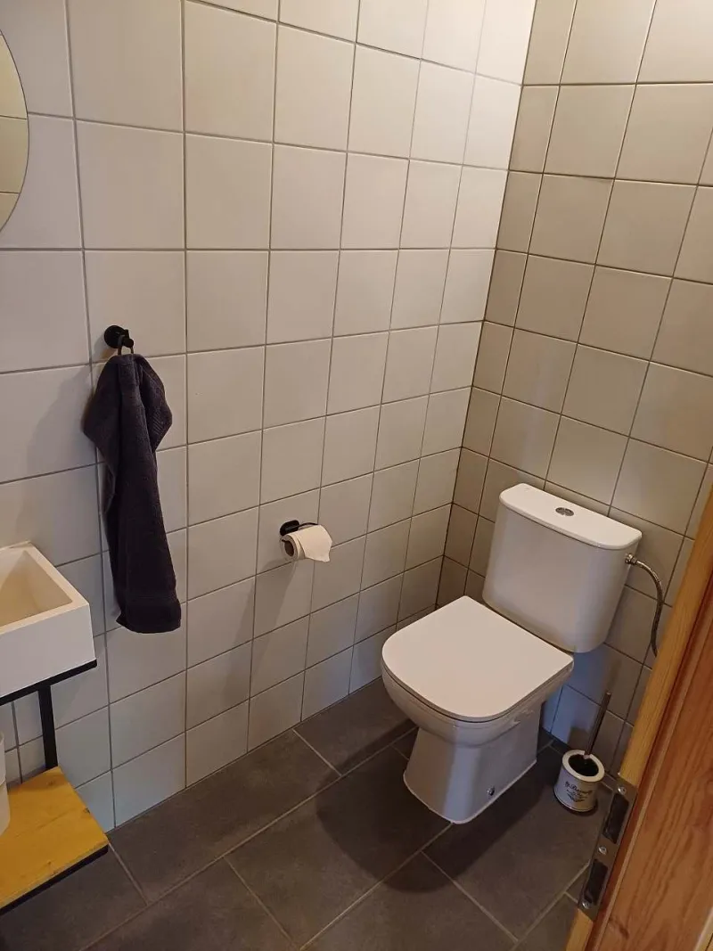 Samostatné WC s umývátkem a světlým obkladem