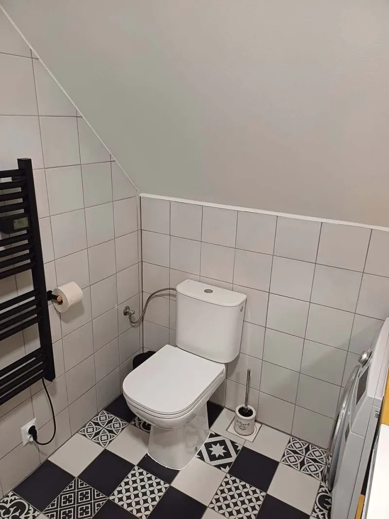 Podkrovní toaleta s černobílou dlažbou