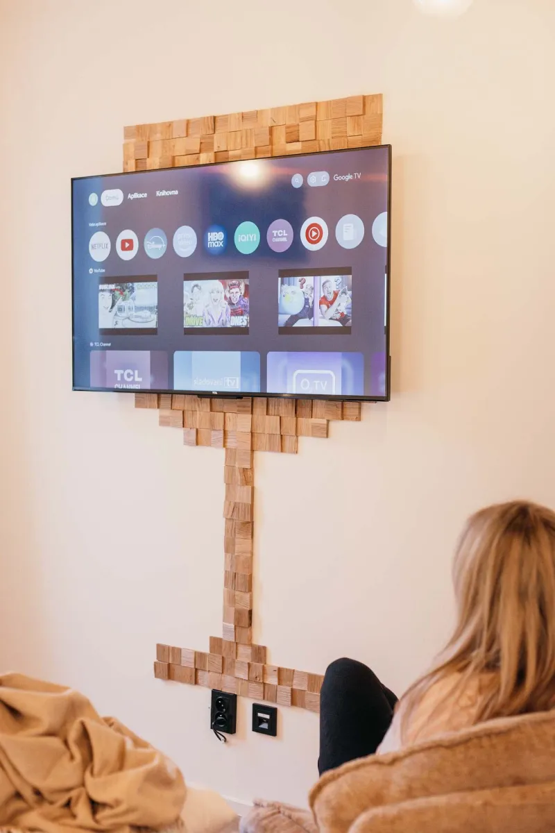Televize na zdi s dřevěným obkladem