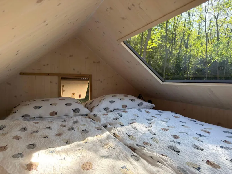 Podkrovní ložnice s oknem do lesa