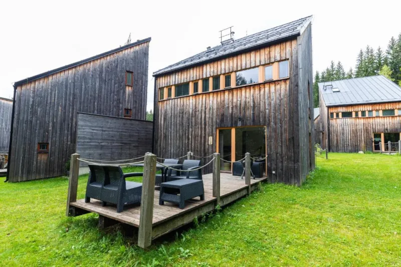 Dřevěné domky s terasou a posezením na trávníku