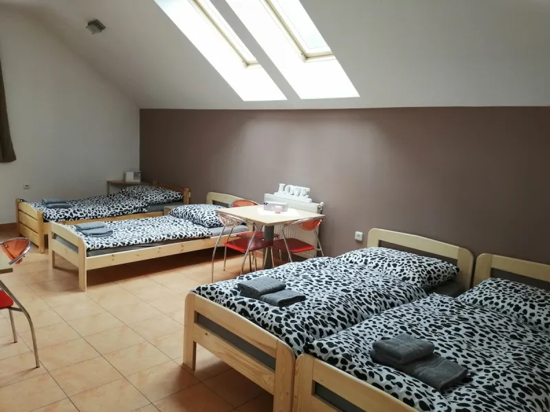 Podkrovní ložnice se čtyřmi samostatnými postelemi