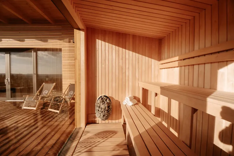Sauna s prosklenou stěnou a terasou s lehátky