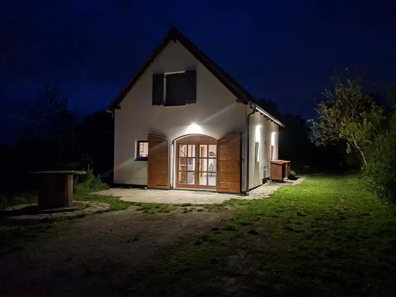 Chalupa s osvětlenými dveřmi v noci
