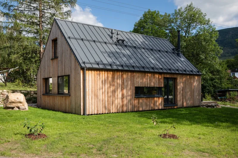 Moderní dřevěná chata s plechovou střechou na zahradě