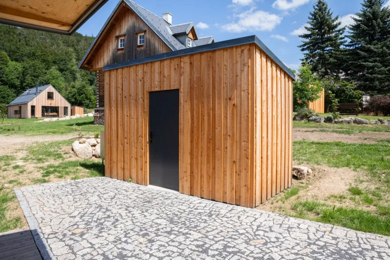 Dřevěný přístavek s kamennou dlažbou u chalup